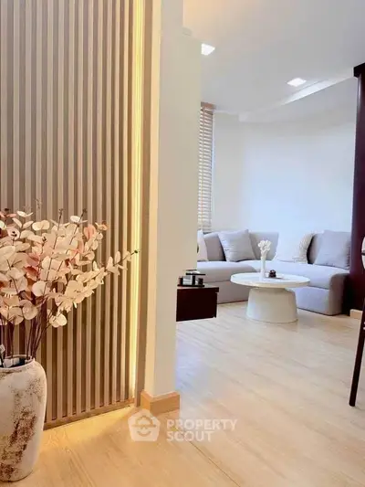 Modern living room with stylish decor and cozy seating area, featuring elegant wooden flooring and soft lighting.