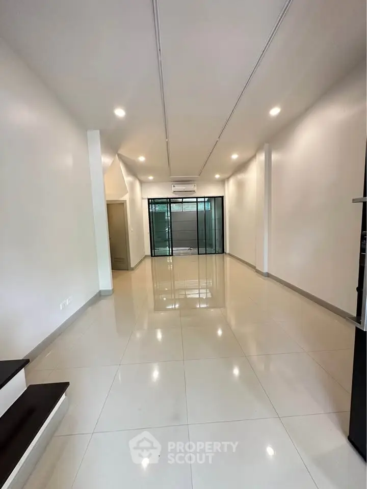 Spacious modern living room with sleek tile flooring and recessed lighting