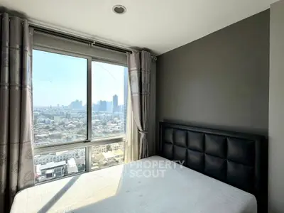 Modern bedroom with city view and large window, featuring a stylish headboard and neutral decor.