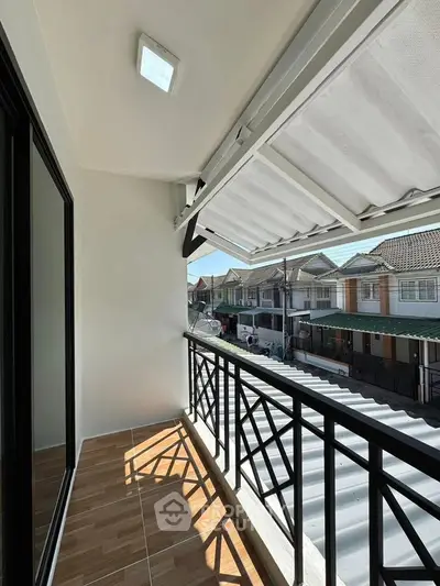 Charming balcony with modern railing and street view, perfect for relaxing outdoors.