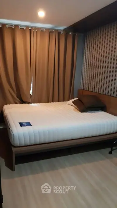 Cozy bedroom with modern design and warm lighting, featuring a comfortable bed and stylish curtains.