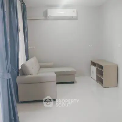 Modern minimalist living room with sleek sofa and air conditioning unit.