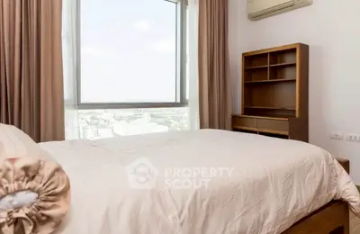 Cozy bedroom with large window offering stunning city view and elegant wooden furniture.