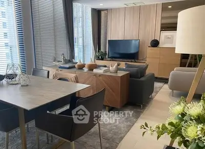 Modern living room with stylish furniture and large windows in a high-rise apartment.