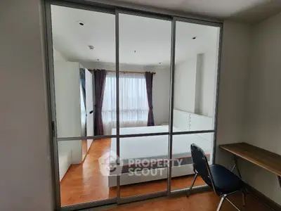 Modern bedroom with glass sliding doors and wooden flooring