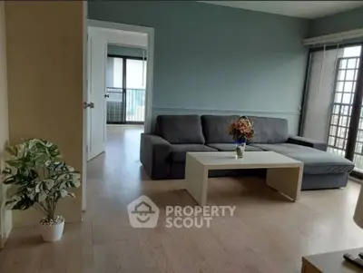 Spacious living room with modern decor and large windows offering natural light.