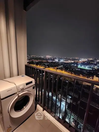 Stunning city night view from high-rise balcony with modern washing machine.