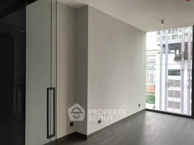 Modern empty room with large windows and city view, sleek flooring and minimalist design.