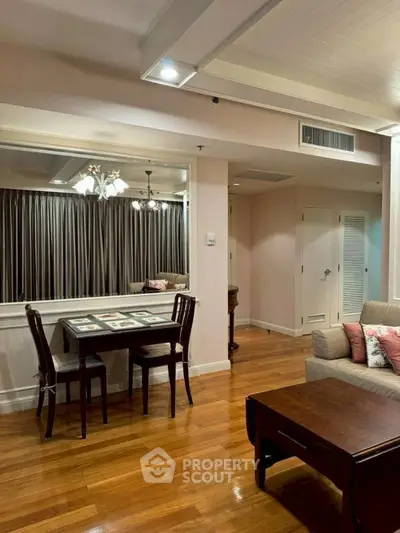 Elegant living room with hardwood floors and cozy dining area in modern apartment.