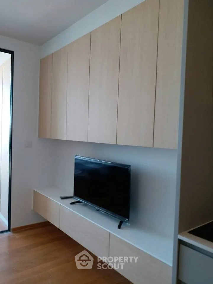 Modern living room with sleek cabinetry and mounted TV, showcasing minimalist design.