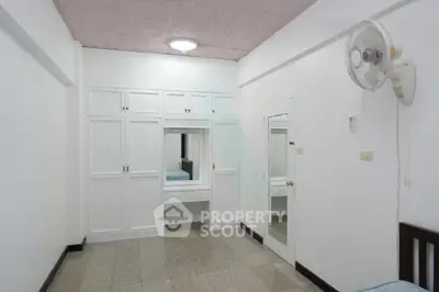Spacious bedroom with built-in wardrobe and ceiling fan, ideal for comfortable living.