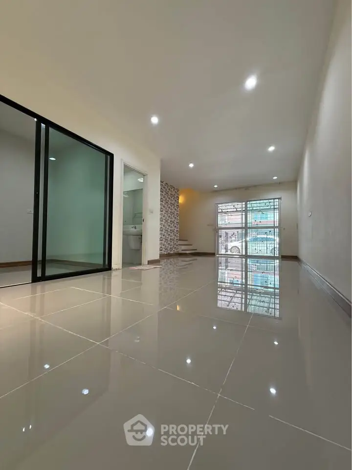 Spacious modern living room with glossy tiled floors and large windows