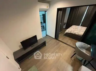Modern apartment interior with cozy bedroom and stylish living area, featuring sleek wooden flooring and contemporary furniture.
