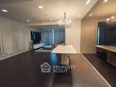 Spacious modern living room with elegant chandelier and large TV setup