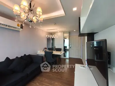 Stylish living room with elegant chandelier and modern furnishings in a cozy apartment.