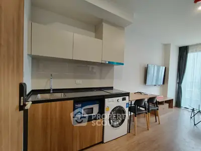 Modern apartment interior with kitchen and living area featuring built-in appliances and stylish decor.