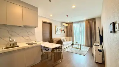 Modern living room with open kitchen, stylish decor, and natural light