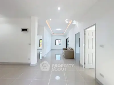 Spacious modern living room with sleek tile flooring and elegant lighting.