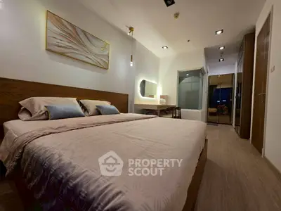 Modern bedroom with elegant decor and ambient lighting, featuring a cozy bed and stylish furnishings.