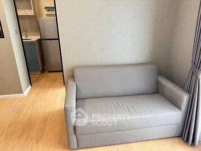 Cozy living room with modern gray sofa and compact kitchen area
