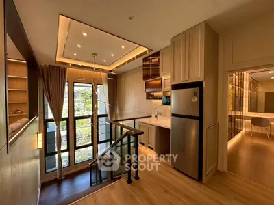 Modern duplex apartment with open kitchen and large windows offering natural light and stylish wooden finishes.