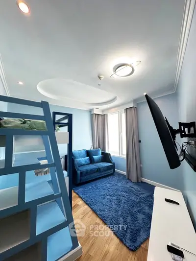 Charming blue-themed living room with bunk bed and cozy sofa, perfect for modern family living.
