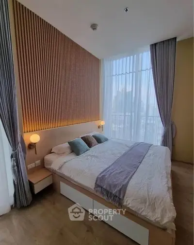 Modern bedroom with stylish wood paneling and floor-to-ceiling windows offering natural light.