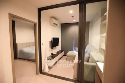 Modern living room with glass partition and cozy bedroom view