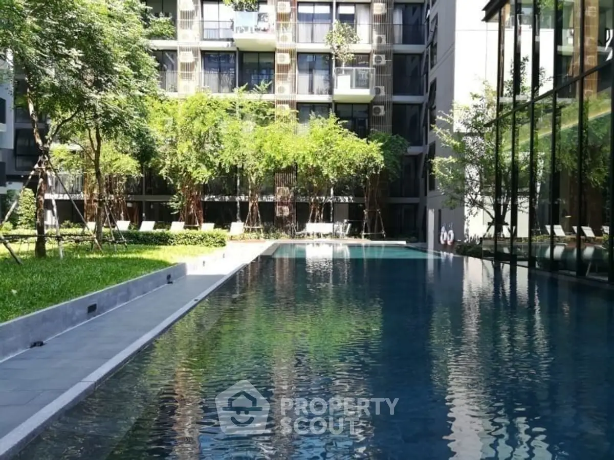 Luxurious condominium with serene pool and lush garden view