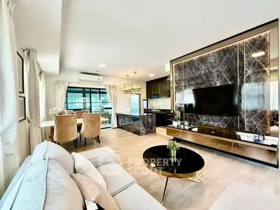 Luxurious modern living room with elegant decor and open kitchen layout.