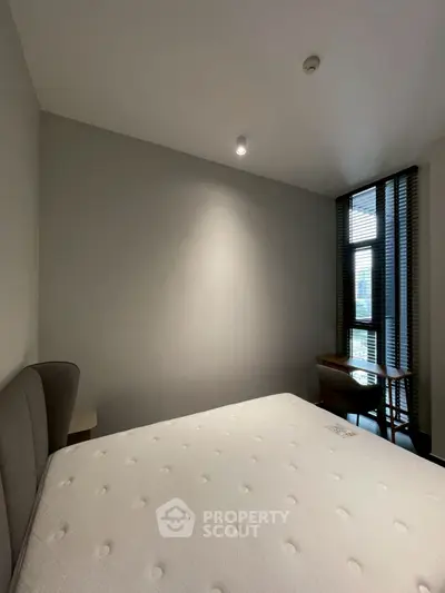 Minimalist bedroom with large window and modern furnishings