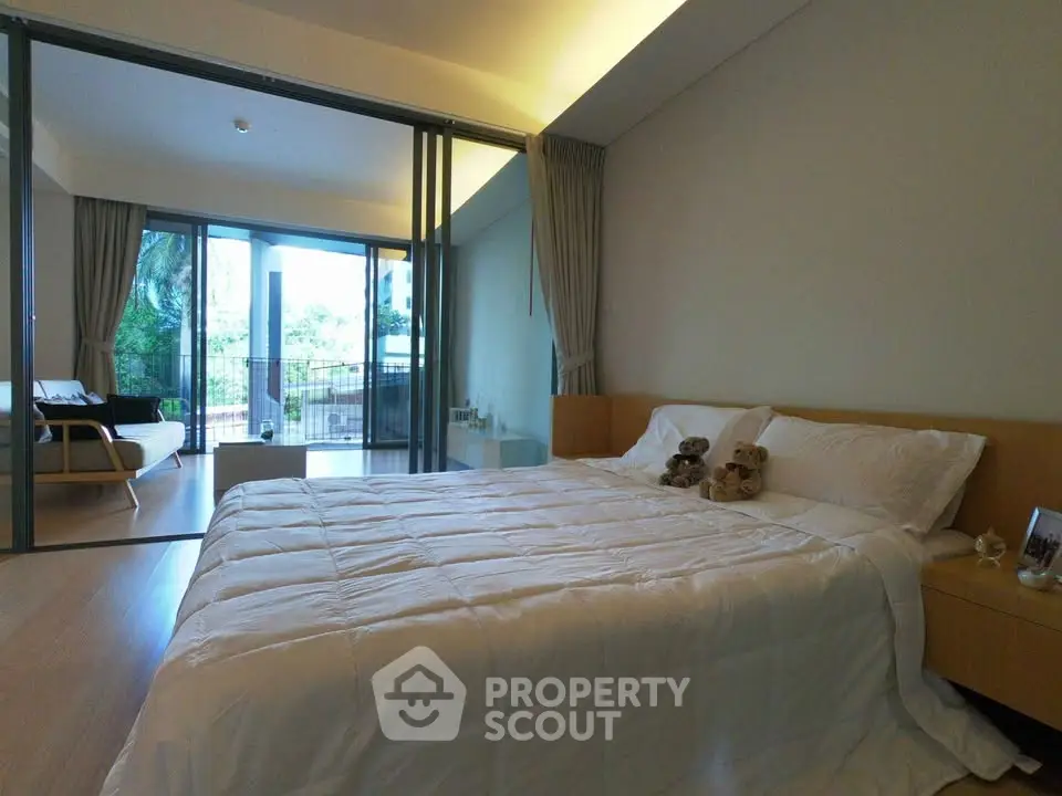 Spacious bedroom with large windows and balcony access, offering serene views and abundant natural light.