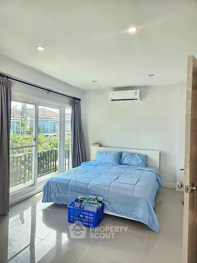 Bright bedroom with large window and modern decor in a cozy home.