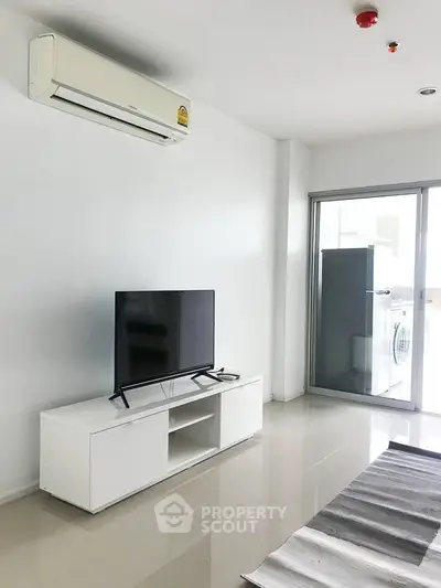 Modern living room with sleek TV setup and air conditioning, featuring a bright and minimalist design.
