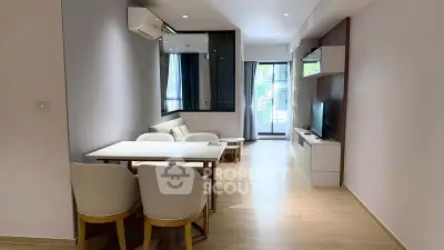 Modern living room with sleek furniture and natural light, featuring a cozy dining area and stylish decor.