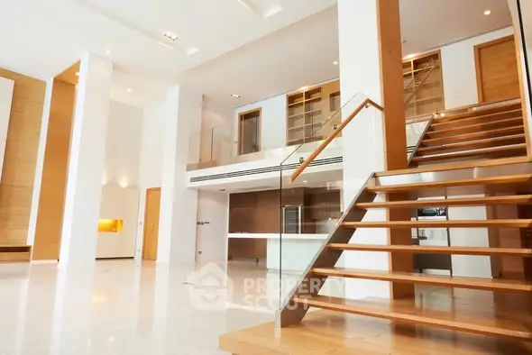 Spacious modern living room with open staircase and high ceilings