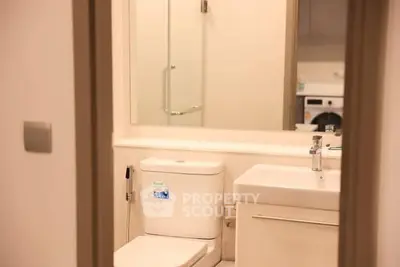 Modern bathroom with sleek fixtures and a glass shower enclosure.