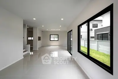 Spacious modern living room with large windows and glossy tiled floors