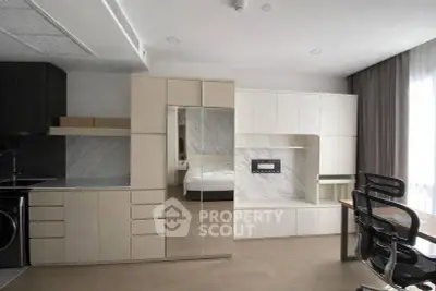 Modern studio apartment with sleek cabinetry and integrated workspace