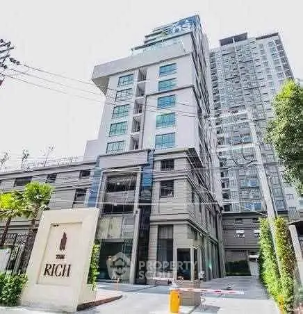 Modern high-rise building exterior with lush greenery and stylish entrance.