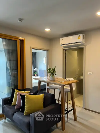 Modern living room with cozy seating and stylish dining area, featuring air conditioning and elegant decor.