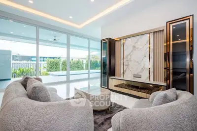 Luxurious living room with modern decor and large windows overlooking a spacious balcony.