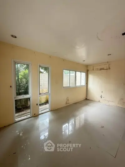 Spacious empty room with large windows and natural light, ideal for customization.