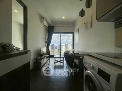 Modern apartment living room with city view, featuring sleek furniture and in-unit washing machine.
