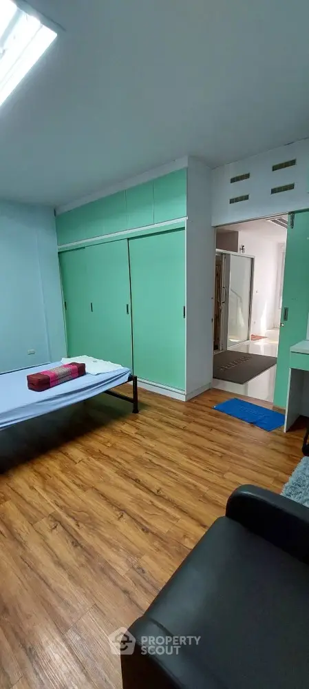 Spacious bedroom with polished wooden flooring, large built-in closets, and ample natural light, leading to a modern en-suite bathroom.