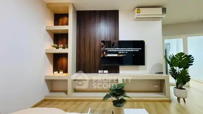 Modern living room with stylish built-in shelves and wall-mounted TV, featuring elegant decor and wooden flooring.