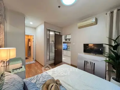 Cozy bedroom with modern decor, air conditioning, and a glimpse into a stylish living area.