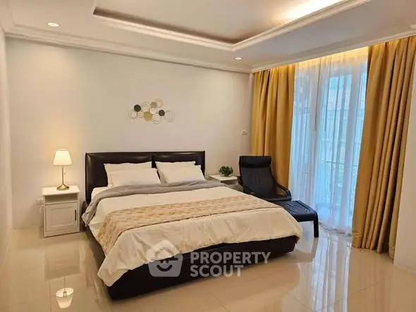 Spacious bedroom with elegant decor and large window for natural light.