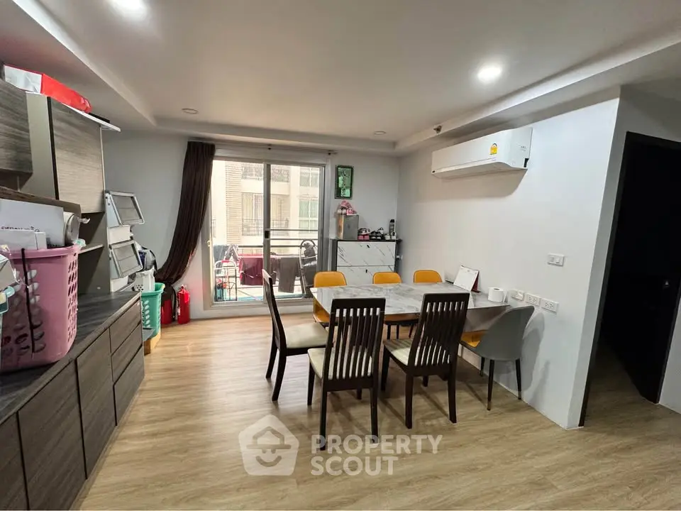 Modern dining area with wooden flooring and balcony access