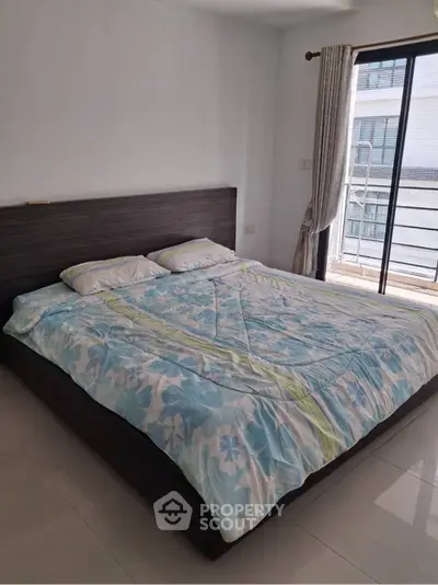Spacious bedroom with large bed and balcony access in modern apartment